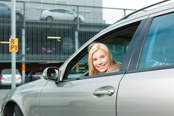 Mujer detrás de su coche en un nivel de estacionamiento — Foto de Stock