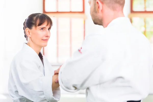 Man and woman fighting at Aikido martial arts school — Stock Photo, Image