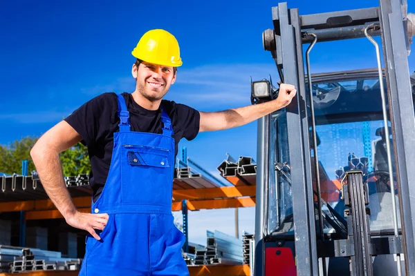 Construtor com transportador de paletes local ou empilhadeira — Fotografia de Stock