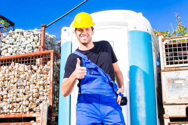 Builder using mobile toilet on site — Stock Photo, Image