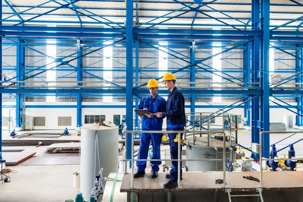 Trabalhadores em grande oficina de metal verificando o trabalho — Fotografia de Stock