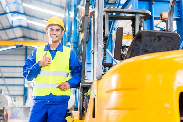 Üretim tesisi ayakta forklift sürücüsü — Stok fotoğraf