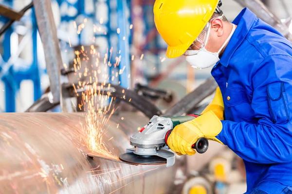 Metalen werknemer in fabriek malen van metal van pijpleiding — Stockfoto