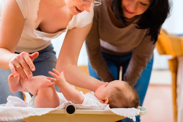 Midwife measuring weight or newborn baby — Stock Photo, Image