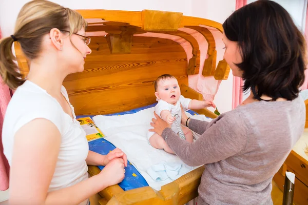 Vroedvrouw bestuderen pasgeboren baby — Stockfoto