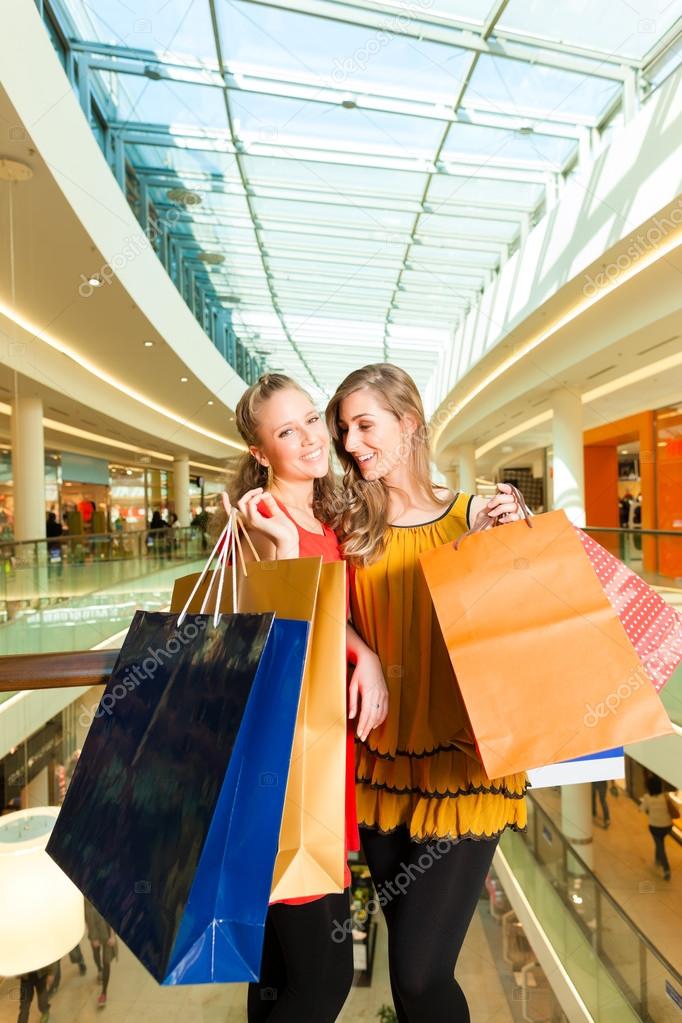 Two women shopping with bags in mall