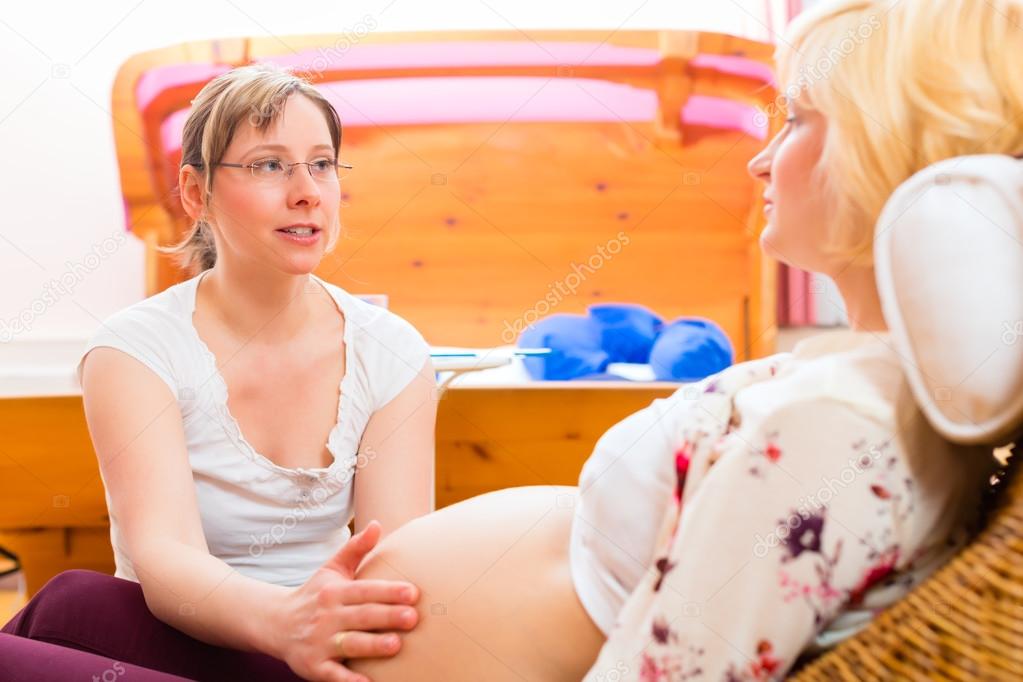 Midwife seeing mother for pregnancy examination