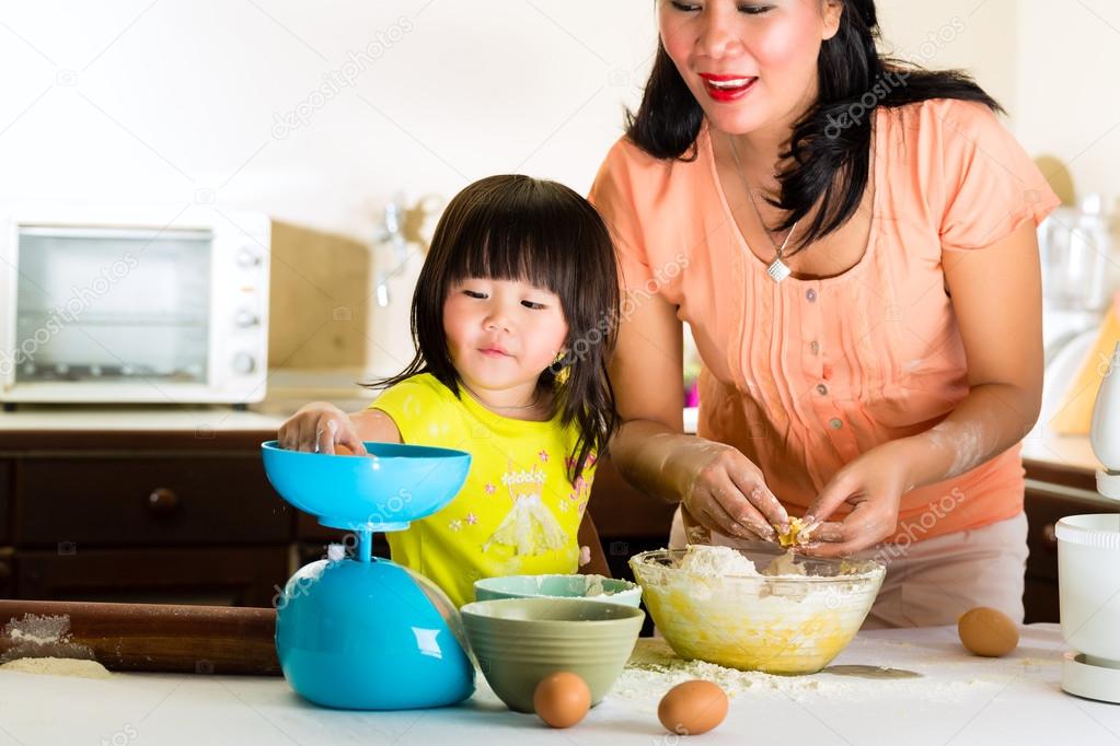 Asian Mother and daughter at home in kitchen