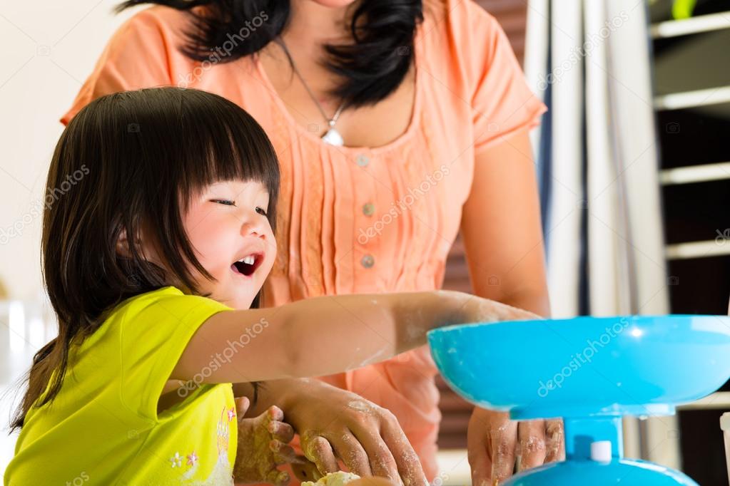 Asian Mother and daughter at home in kitchen