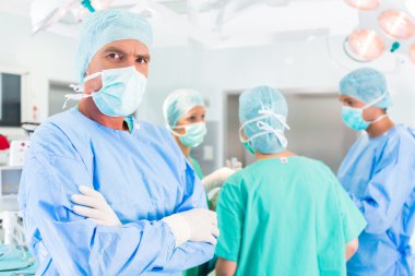 Hastane cerrahları ameliyathanede ameliyat yapıyor.