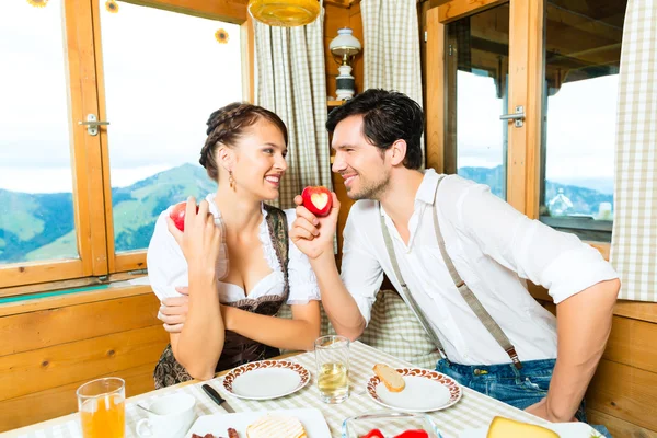 Young couple in mountain chalet eating — 스톡 사진