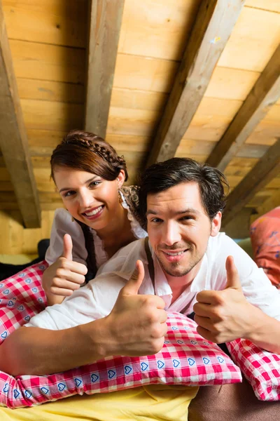 Pareja con ropa de cama en cabaña de montaña — Foto de Stock