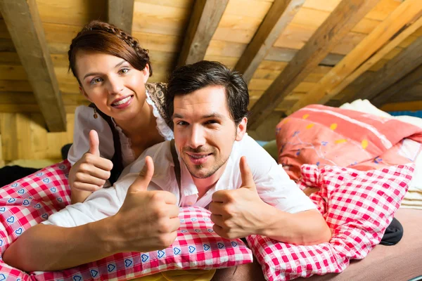 Couple with bed clothes in mountain cabin — ストック写真