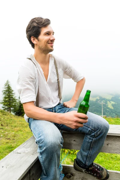 Alps - Man in mountains drinking beer from bottle — Stok fotoğraf