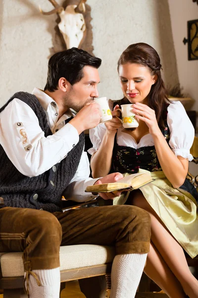 Pareja joven en la cabaña de un cazador tomando té — Foto de Stock