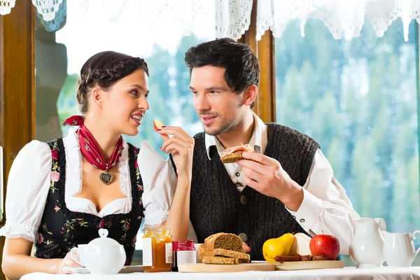 Casal jovem na cabana de um caçador comendo — Fotografia de Stock