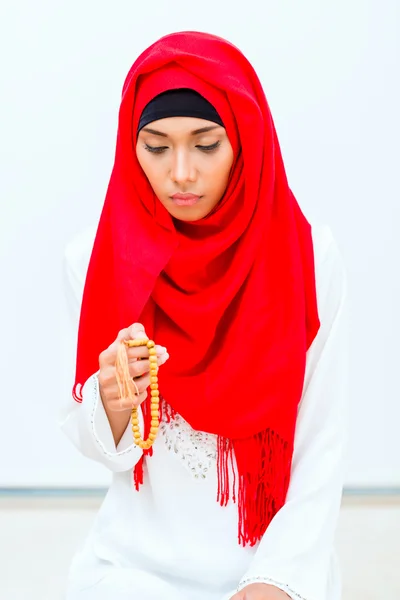 Азиатская мусульманка молится цепью из бусин — стоковое фото