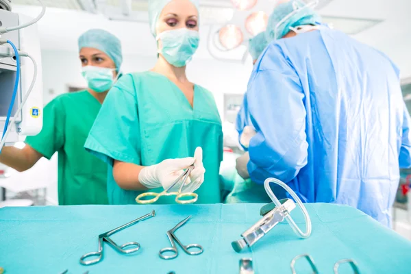 Cirurgiões operando paciente na sala de cirurgia — Fotografia de Stock