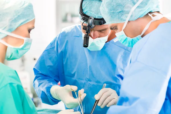 Хирурги, оперирующие пациента в операционной — стоковое фото
