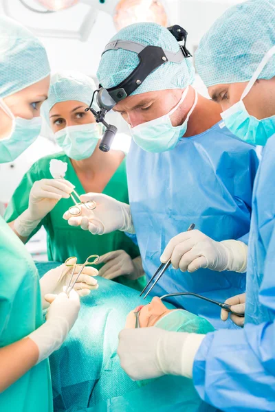 Хирурги, оперирующие пациента в операционной — стоковое фото