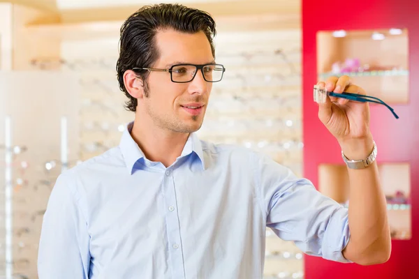 Jonge man op opticien met glazen — Stockfoto