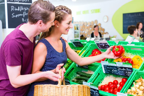 Pareja seleccionando verduras en tienda de esquina — Foto de Stock