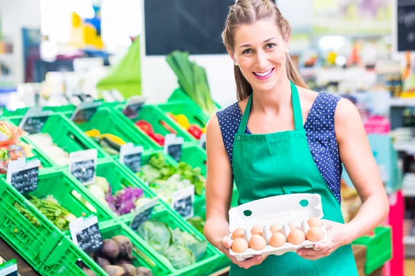 Organic grocery shop clerk offering eggs — Stock Photo, Image