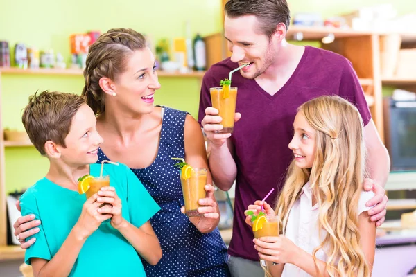 Família beber smoothie ou suco na cozinha doméstica — Fotografia de Stock