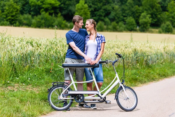 Pár lovaglás tandem kerékpár együtt az ország — Stock Fotó