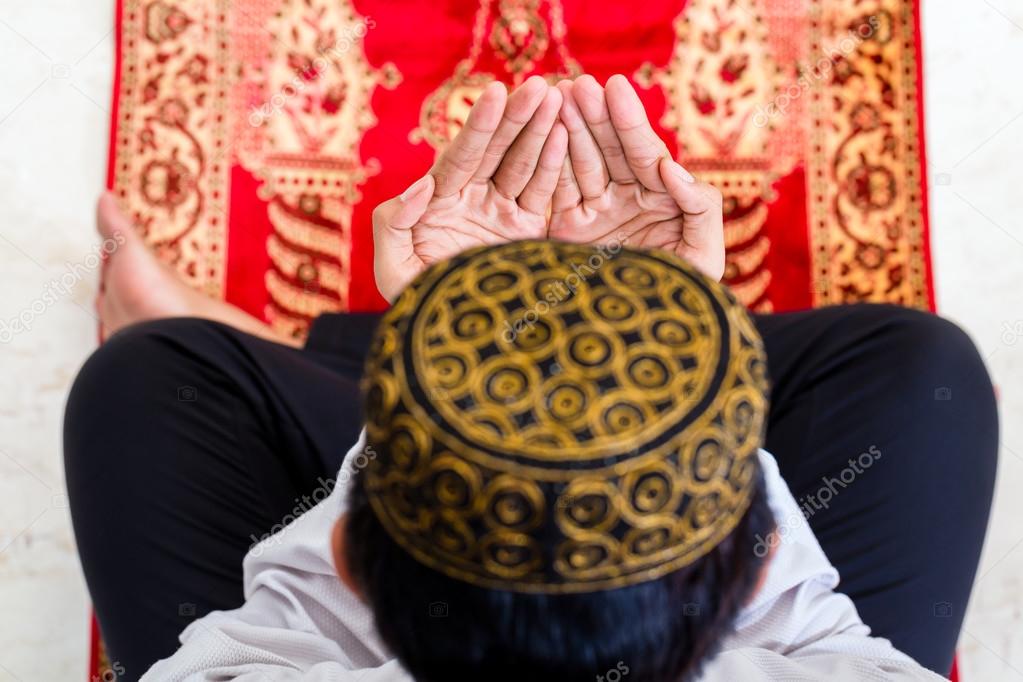 Asian Muslim man praying on carpet