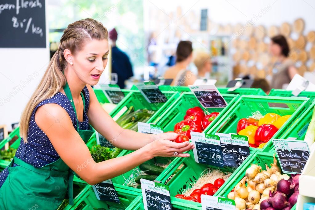 Corner shop clerk filling up storage racks