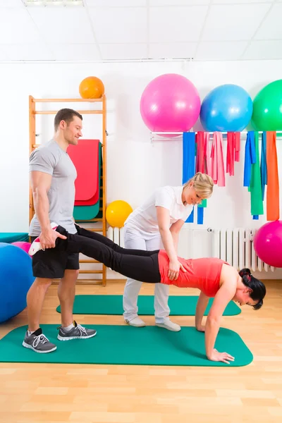 Physiotherapist giving patients gymnastic exercise — Stock Photo, Image