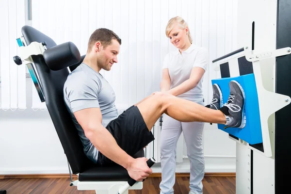 Fisioterapeuta ejercitando al paciente en terapia deportiva — Foto de Stock