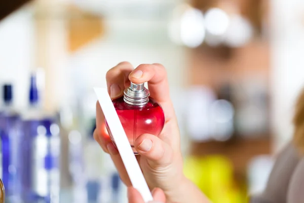 Woman buying perfume in shop or store — Stock Photo, Image