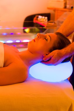 Woman enjoying therapy in spa with color therapy clipart