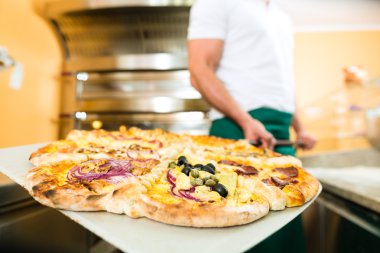 Adam bitmiş pizza fırından iterek