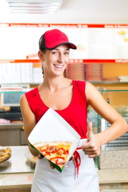 Kadın bir dilim pizza yiyor.