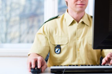 Police Officer working on desk in department clipart