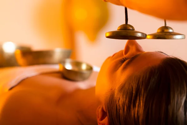 Жінка в оздоровчому масажі з співочими чашами — стокове фото