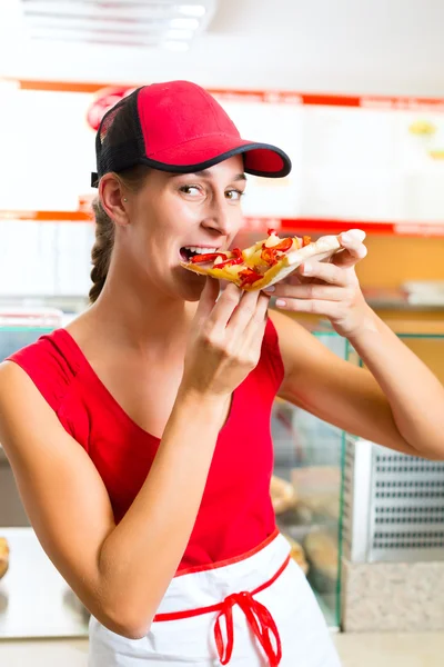 Žena jí kousek pizzy — Stock fotografie
