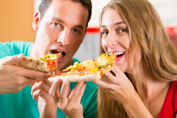 Mann und Frau essen eine Pizza — Stockfoto