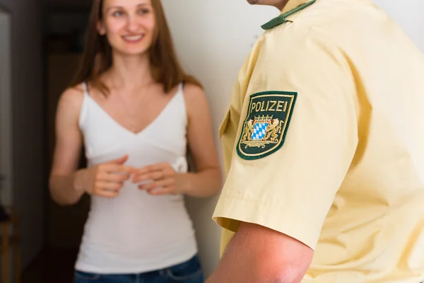 Polizist verhört Frau vor Haustür — Stockfoto