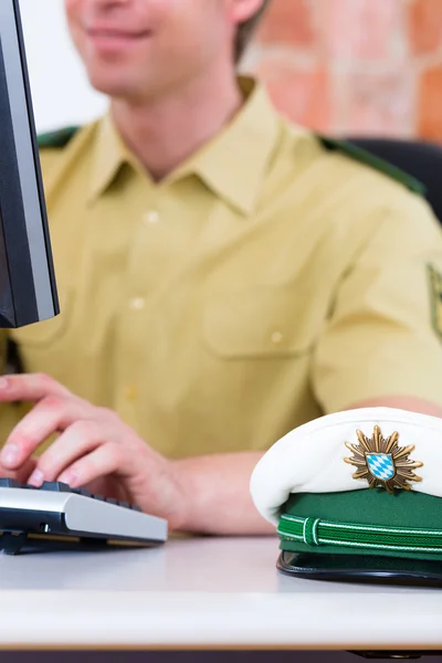 Polizist arbeitet am Schreibtisch im Bahnhof — Stockfoto