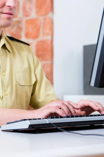 Polizist arbeitet am Schreibtisch in Abteilung — Stockfoto