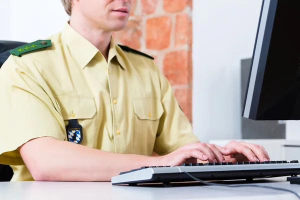 Polizist arbeitet am Schreibtisch in Abteilung — Stockfoto