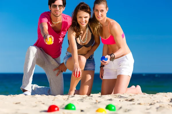 Homme et femmes jouant boule sur la plage — Photo