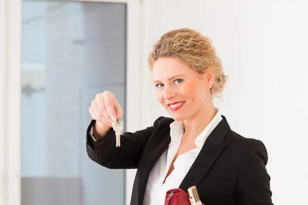 Jonge makelaar is met sleutels in een appartement — Stockfoto