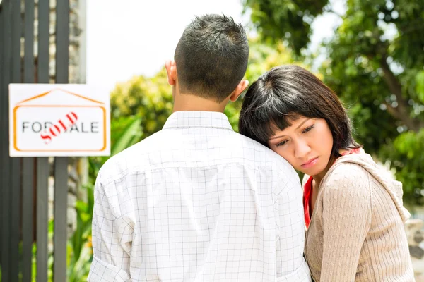 Disappointed asian couple in front of a house — Stock Photo, Image