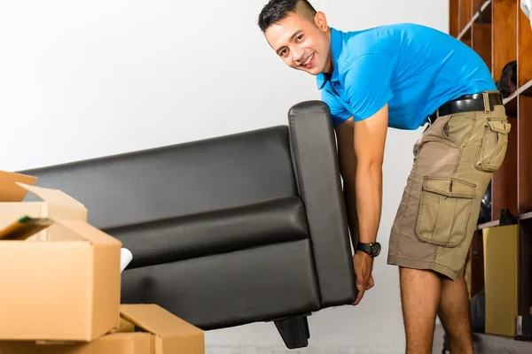 Jovem asiático homem levantando um sofá — Fotografia de Stock