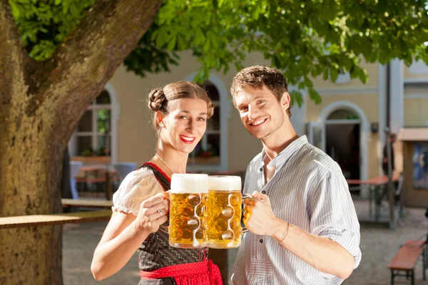 Casal com cerveja stein e roupas tradicionais — Fotografia de Stock